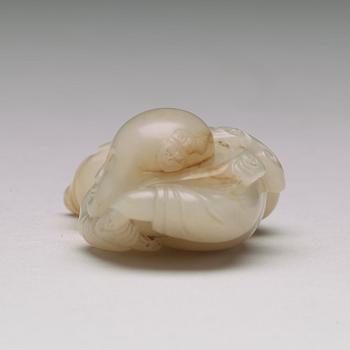 A nephrite figure of a reclining boy holding a lingzhi fungus, 20th Century.