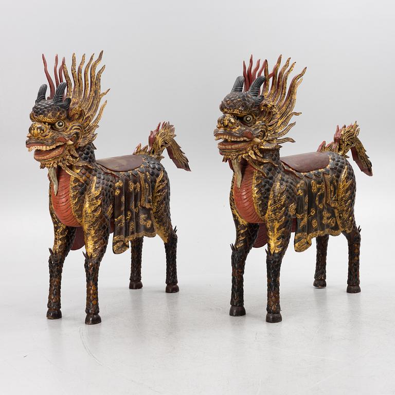 A pair of large Qilin sculptures, lacquered wood, first part of the 20th century.