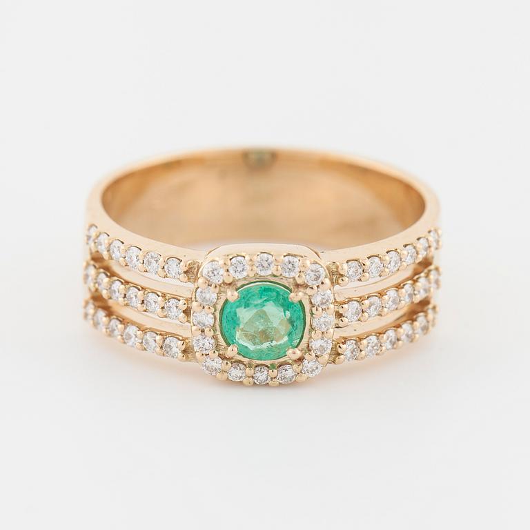 An emerald and brilliant cut diamond ring.