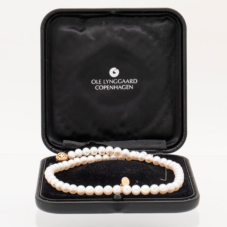 Ole Lynggaard, lås "Lace" 18K guld med briljantslipade diamanter samt collier av odlade sötvattenpärlor.