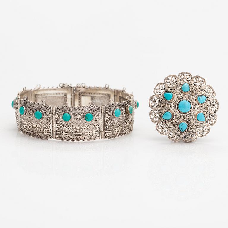 A silver bracelet and ring with turquoises. China.