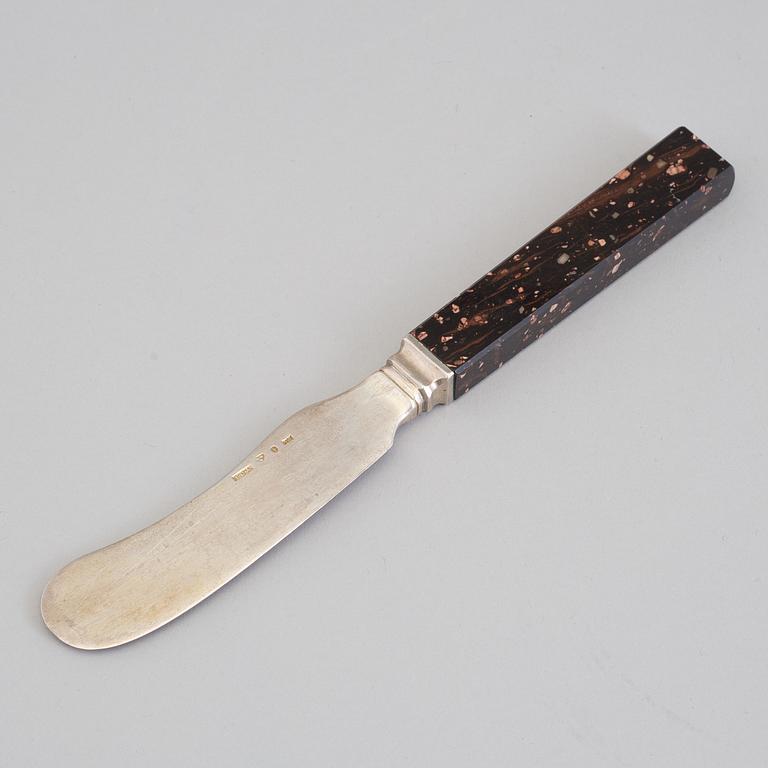 A silver butterknife with porphyry shaft, dated 1853.