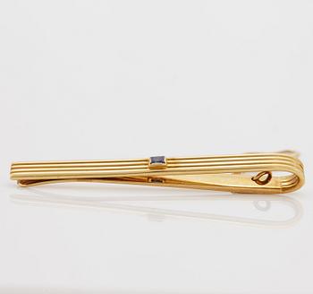 A 1960/70's tie-clip decorated with a carré-cut sapphire by Dupont, Paris.