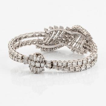 A platinum bracelet set with round brilliant- and baguette-cut diamonds.
