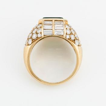 An 18K gold ring with an emerald-cut emerald and baguette and round brilliant-cut diamonds.