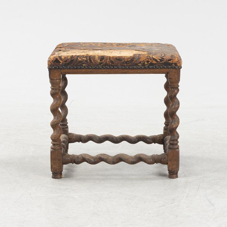 A turned oak Baroque style stool, 19thb Century, covered with older gilt leather.