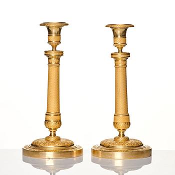 A pair of French gilded Empire candlesticks, early 19th century.