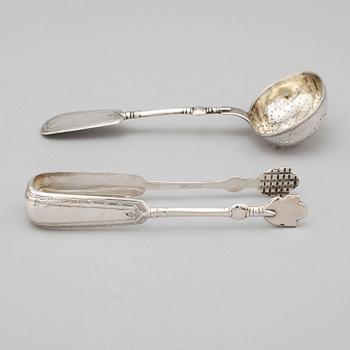 A Russian 19th century silver straining spoon and a pair of sugar tongs, St. Petersburg 1893.