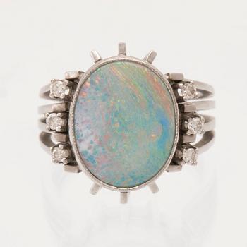 A 14K white gold ring set with an opal doublet or triplet and round brilliant-cut diamonds.