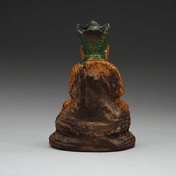 A yellow and green glazed pottery figure of a seated Buddha, Ming dynasty, 17th century.