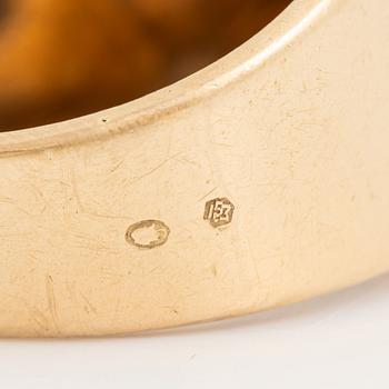An 18K gold ring set with a faceted sapphire and diamonds.