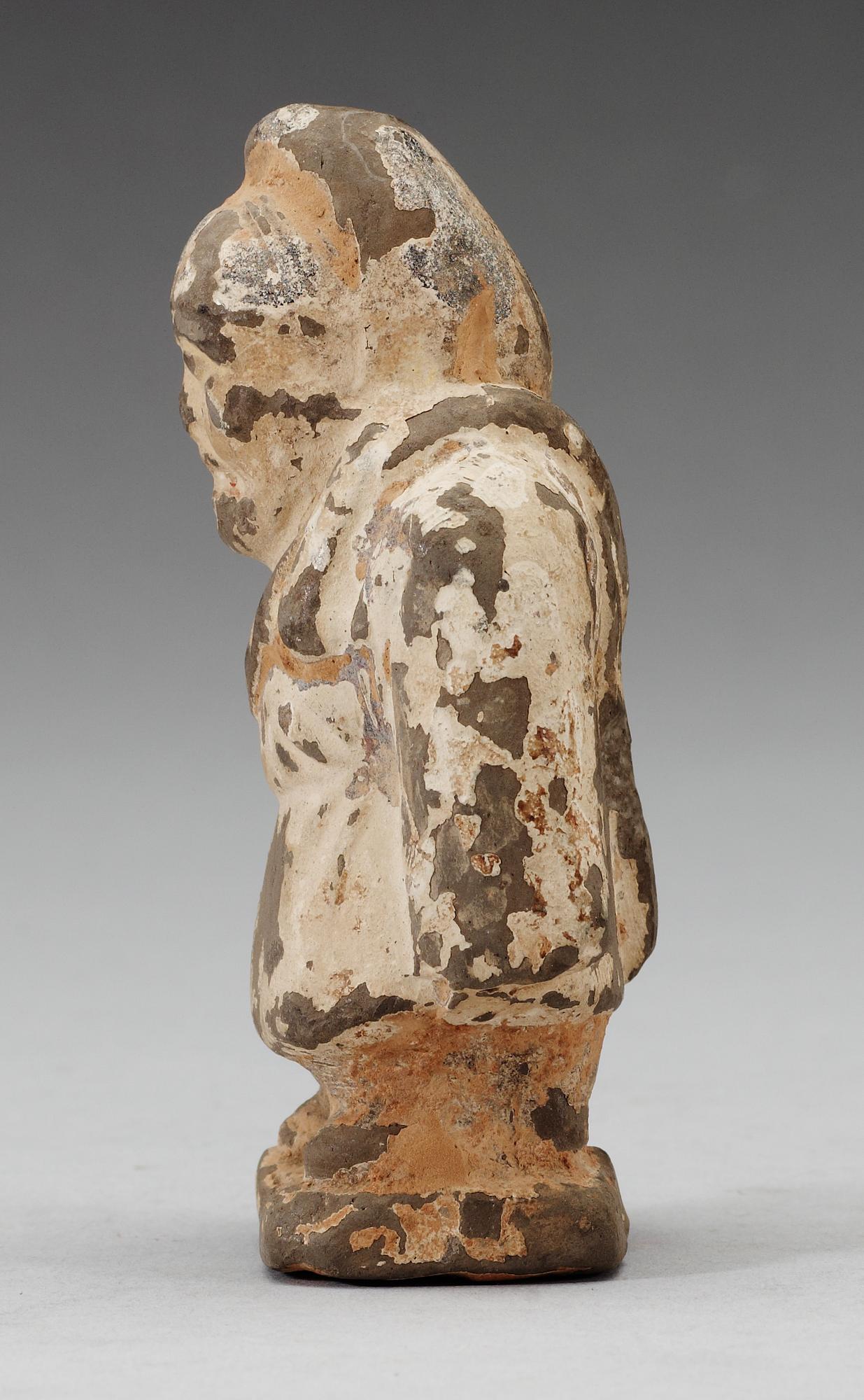 A small potted figure of a man, Han dynasty (206 BC - 220 AD).