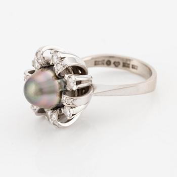 An 18K white gold ring set  with a pearl and round brilliant-cut diamonds.