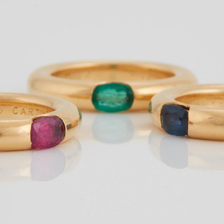Cartier tre ringar "Ellipse" 18K guld med fasettslipad safir, smaragd och rubin.