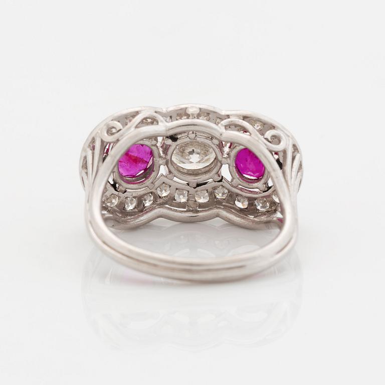 An 18K white gold ring set with faceted rubies and a round brilliant-cut diamond and eight-cut diamonds.