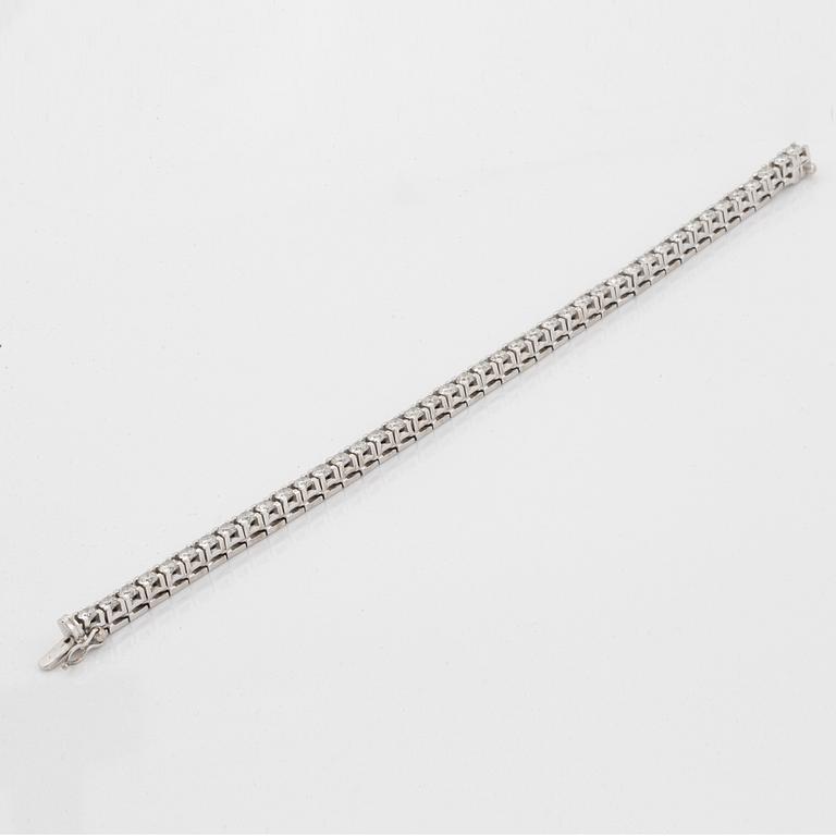 A tennis bracelet in 18K gold set with round brilliant-cut diamonds.