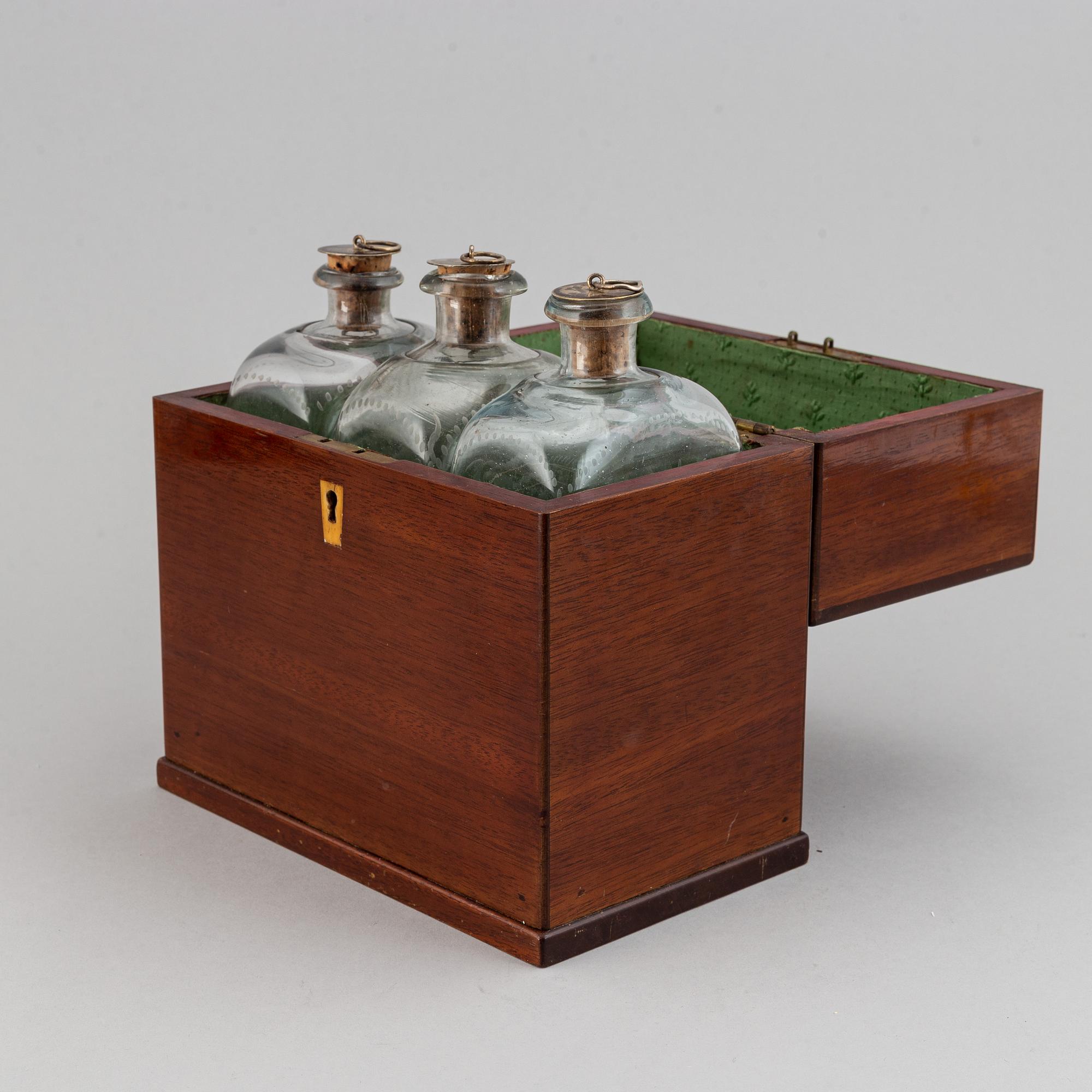 A late Empire mahogany box with three glass bottles, mid 19th Century.