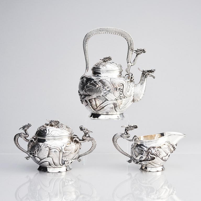 A three piece japanse silver 'dragon' tea set, Signed 三代目 大島, third generation Oshima, early 20th Century.