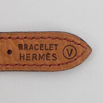HERMÈS, a burgundy red leather braclet with 14k gold plated watch, "Kelly Lock".