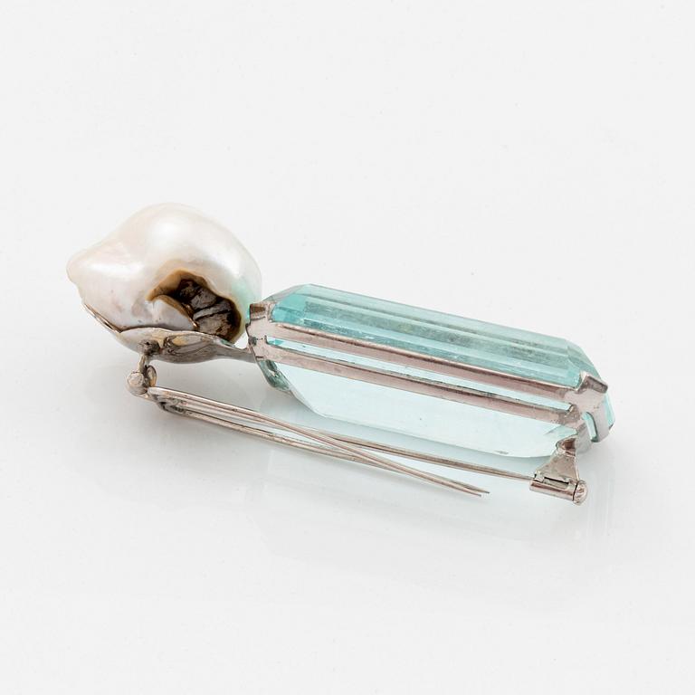 A Tina Karlsson brooch "Cat" in 18K white gold set with a large step-cut aquamarine and a cultured pearl.