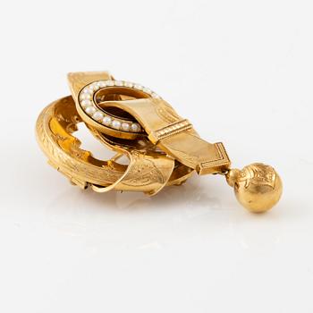 A brooch in 18K gold with pearls and black enamel.
