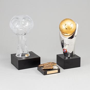 A collection of three soccer sculptures.