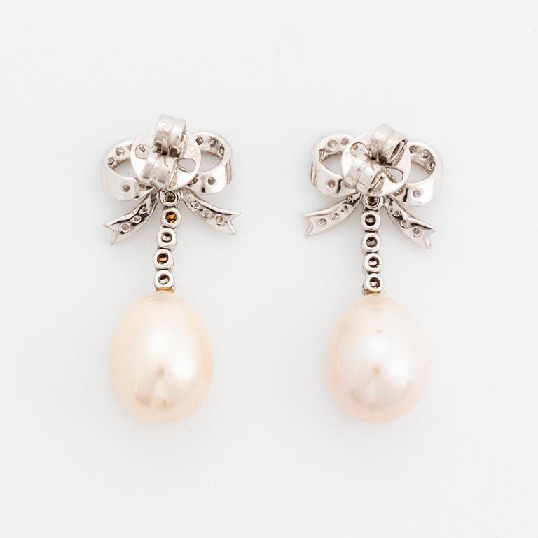 A pair of 18K gold and cultured pearl earrings set with round brilliant-cut diamonds.