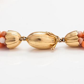 A 6-strand pearl collier with coral pearls and an 18K gold clasp.
