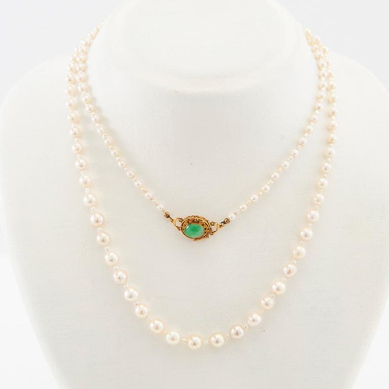 Necklace of cultured pearls with a clasp of 18K gold and cabochon-cut green stone.