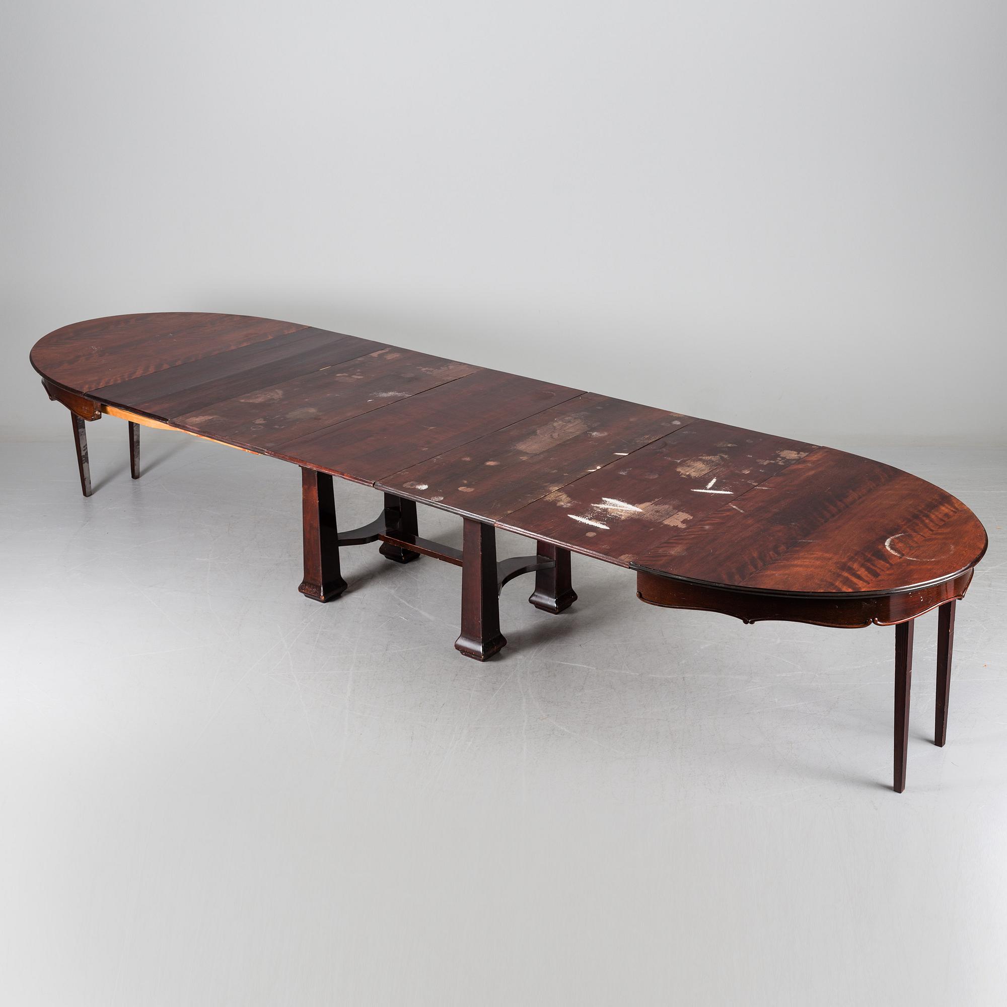 A late 19th century dining table with ten chairs and five extension leaves.