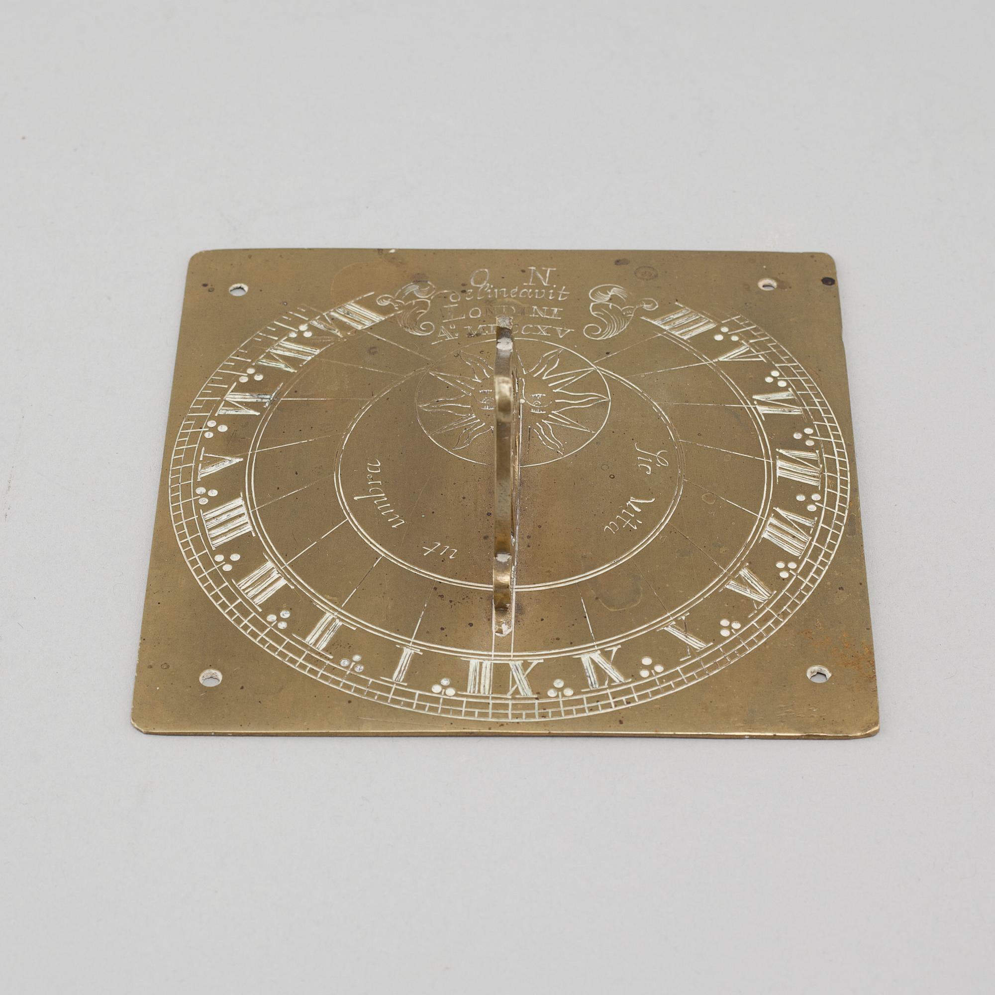 A brass sundial dated 1715.