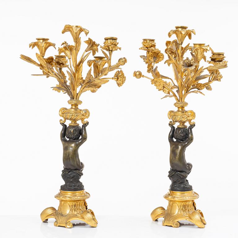 A Rococo style mantle clock and pair of candelabra, France, late 19th Century.