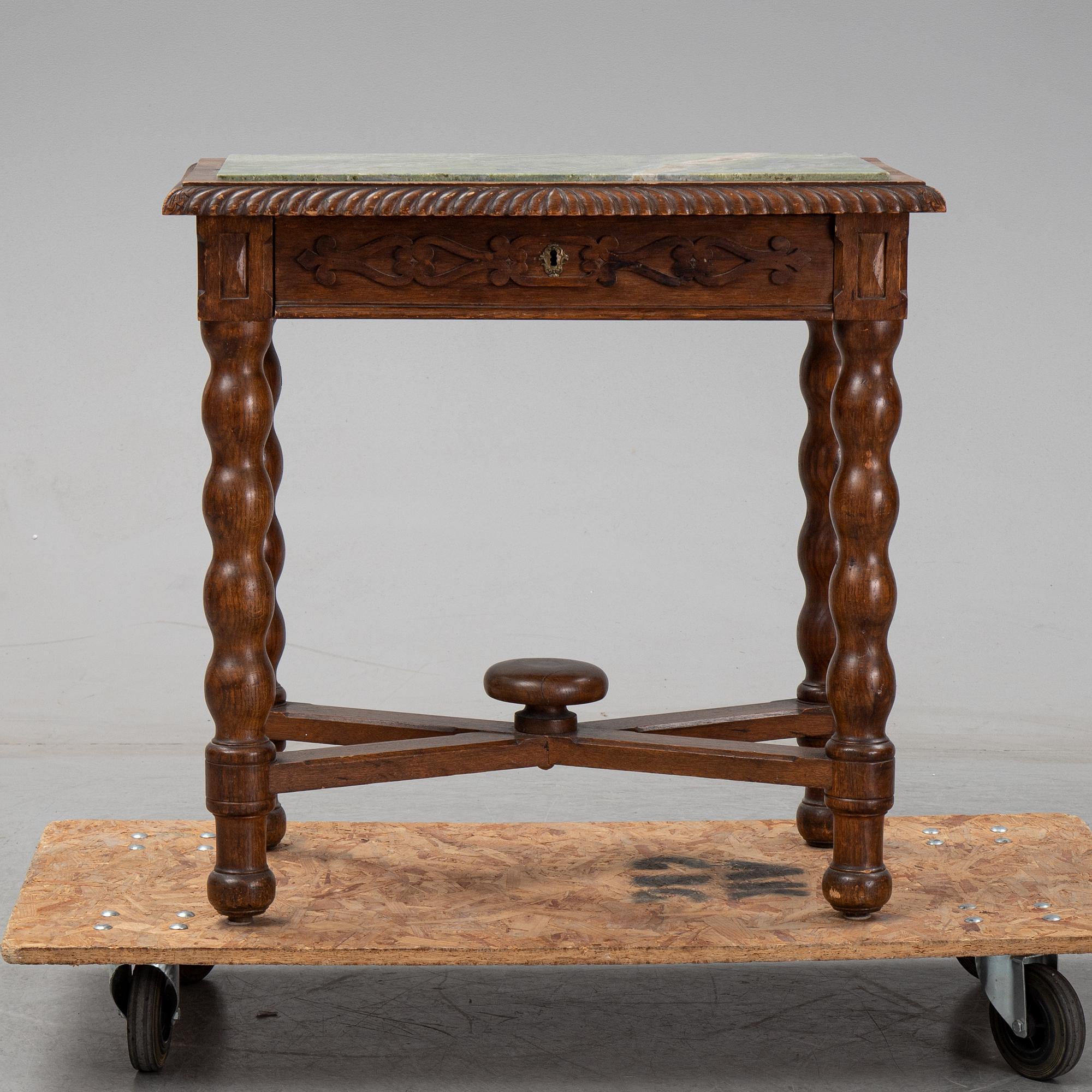 An early 20th Century oak side table with a stone top.