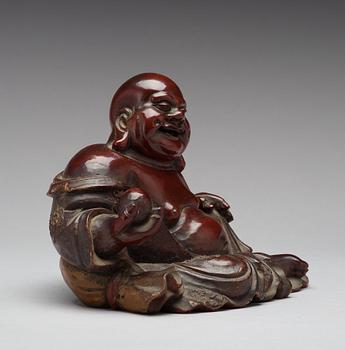 A seated wooden figure of Buddai, Qing dynasty, circa 1900.