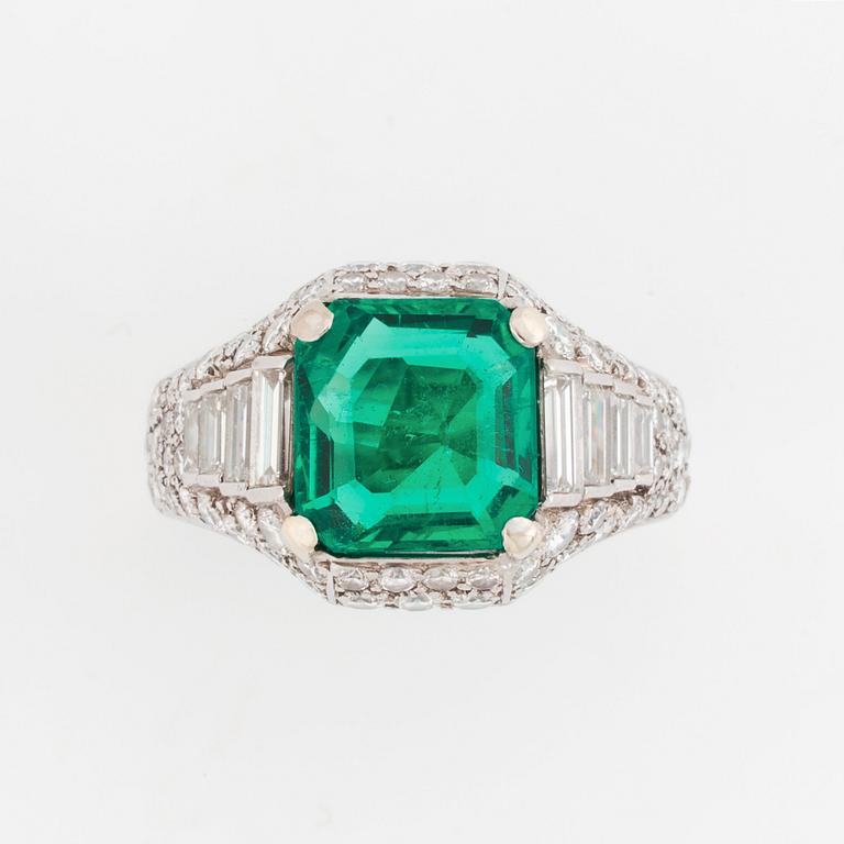 A Bulgari "Trombino" ring in platinum set with a step-cut emerald and round brilliant- and baguette-cut diamonds.