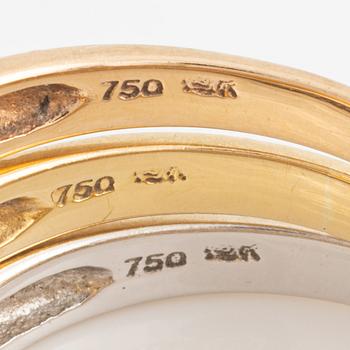 Three 18K gold rings with round brilliant-cut diamonds.