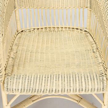 A mid-20th-century three-piece rattan furniture set including two armchairs, and a table.