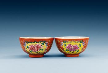 1652. A pair of coral-ground famille rose bowls, Qing dynasty (1644-1912), one with seal mark in red.