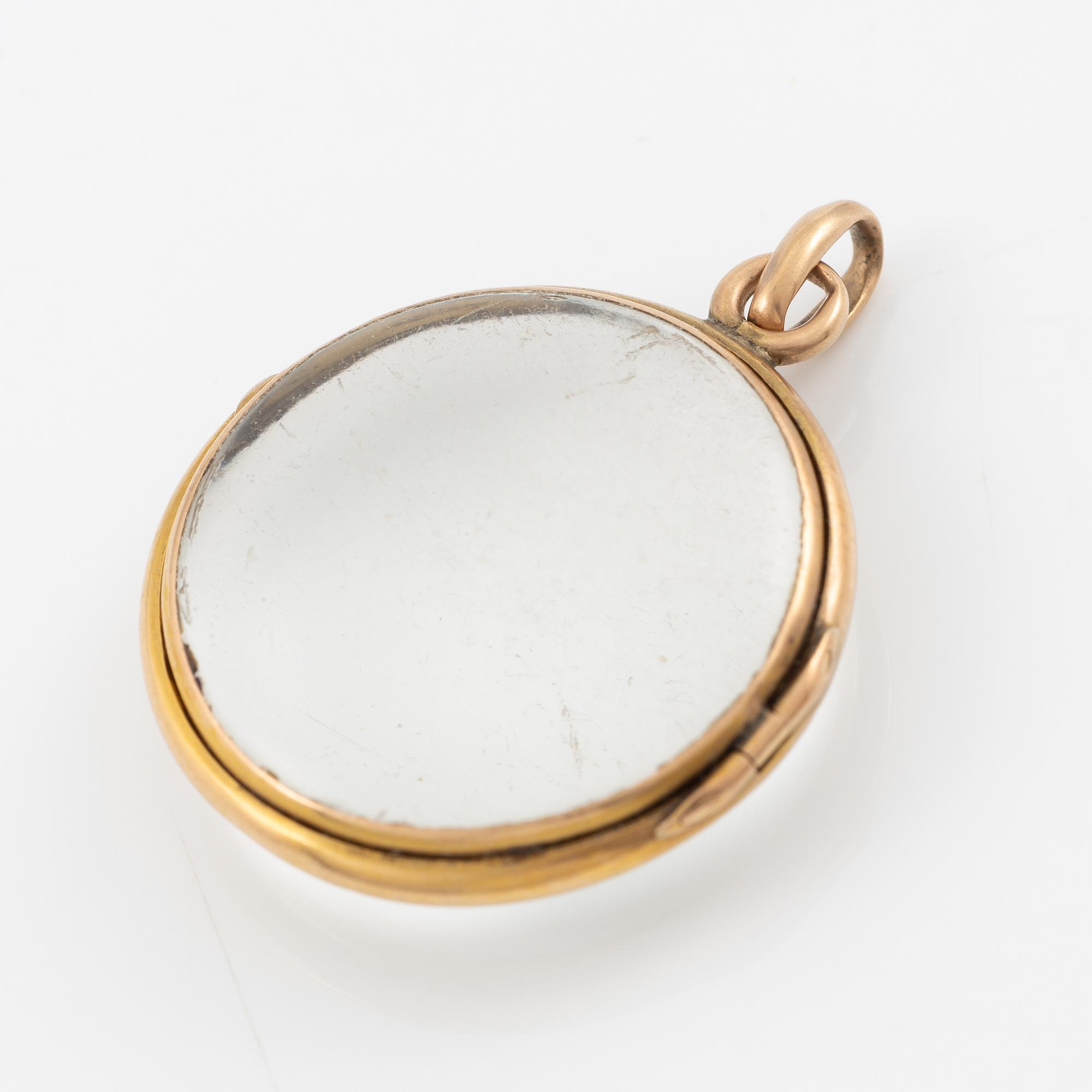 Medaljong, guld och glas.
