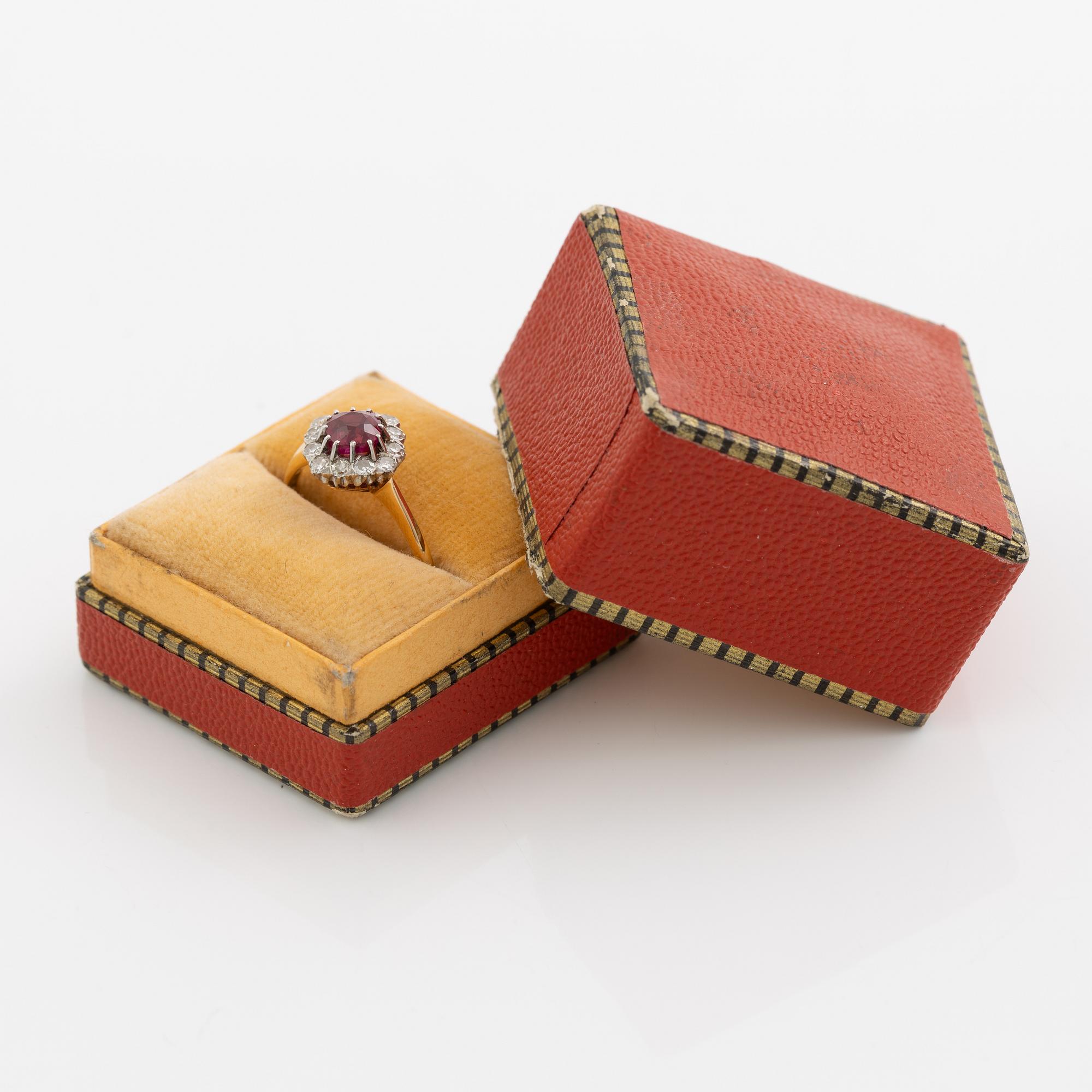 Ring in 18K gold set with a faceted synthetic ruby and eight-cut diamonds.