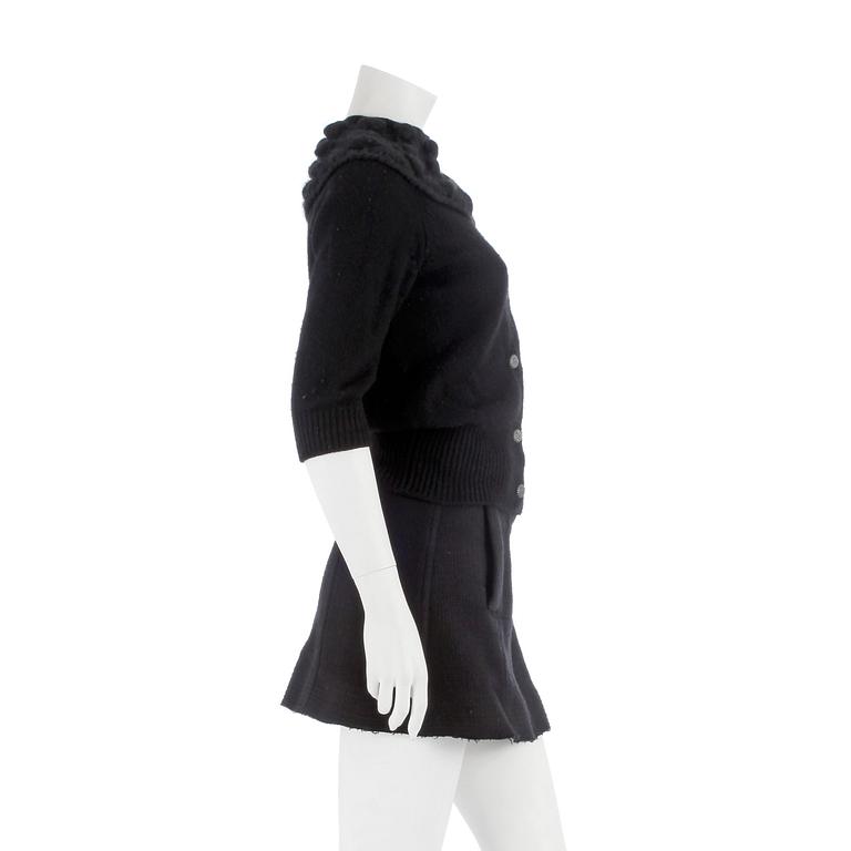 CHANEL, a black cashmere carding and a bouclé skirt.