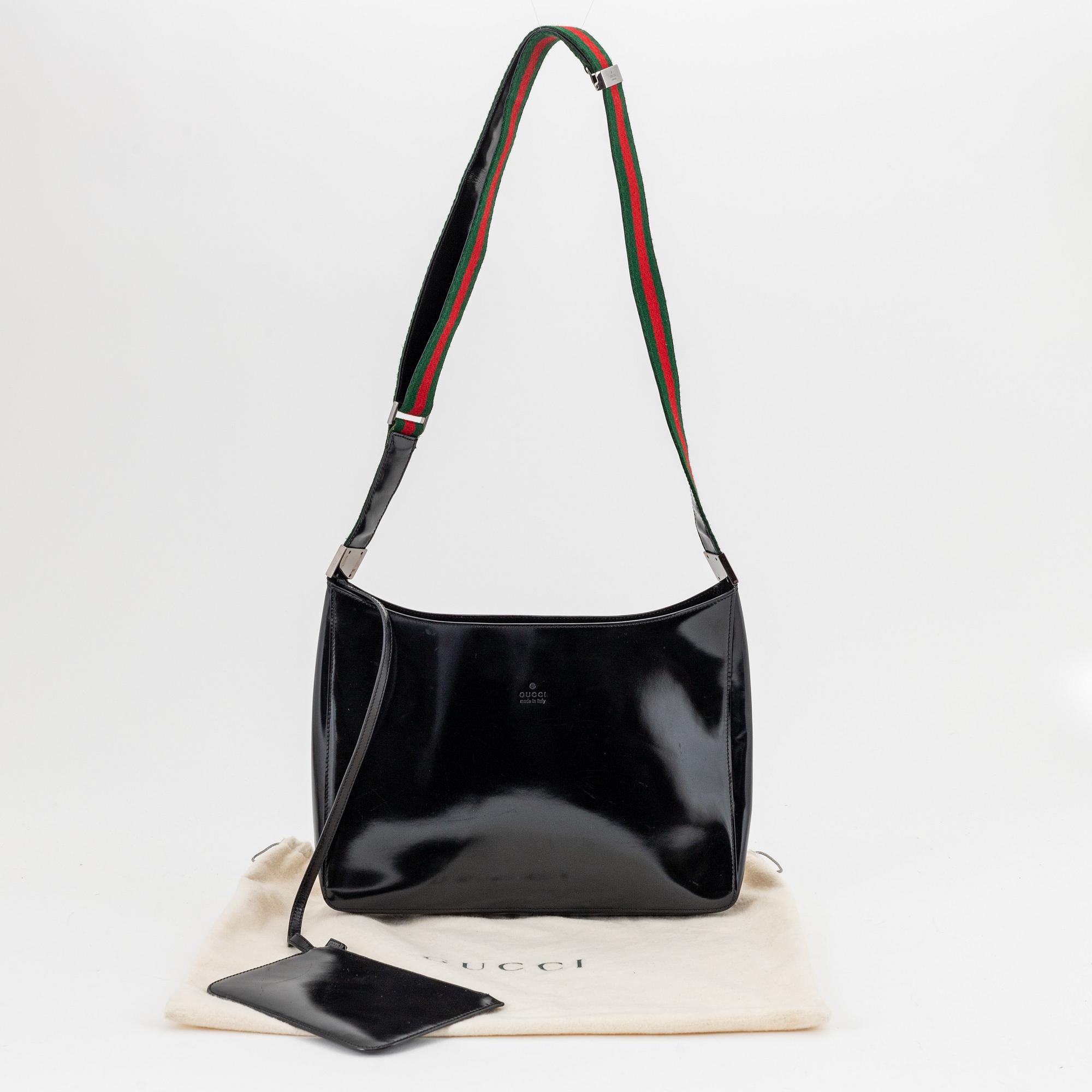 Gucci, a black, patent leather handbag.