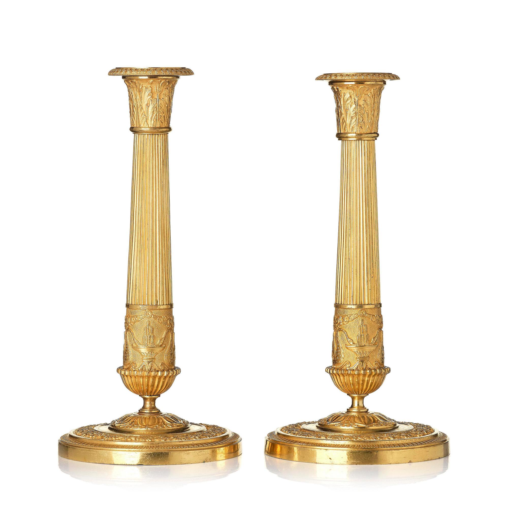 A pair of French Empire ormolu candlesticks, early 19th century.