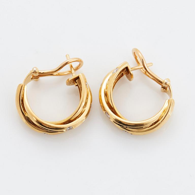 A pair of Cartier "Trinity" earrings in 18K gold set with round brilliant-cut diamonds.