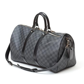 A black damier ebene canvas weekend bag by Louis Vuitton.