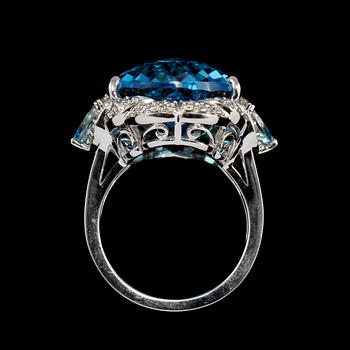 RING, 18k vitguld med checkerslipad blå topas, 2 fasettslipade akvamariner och 68 briljantslipade diamanter. Vikt 14g.