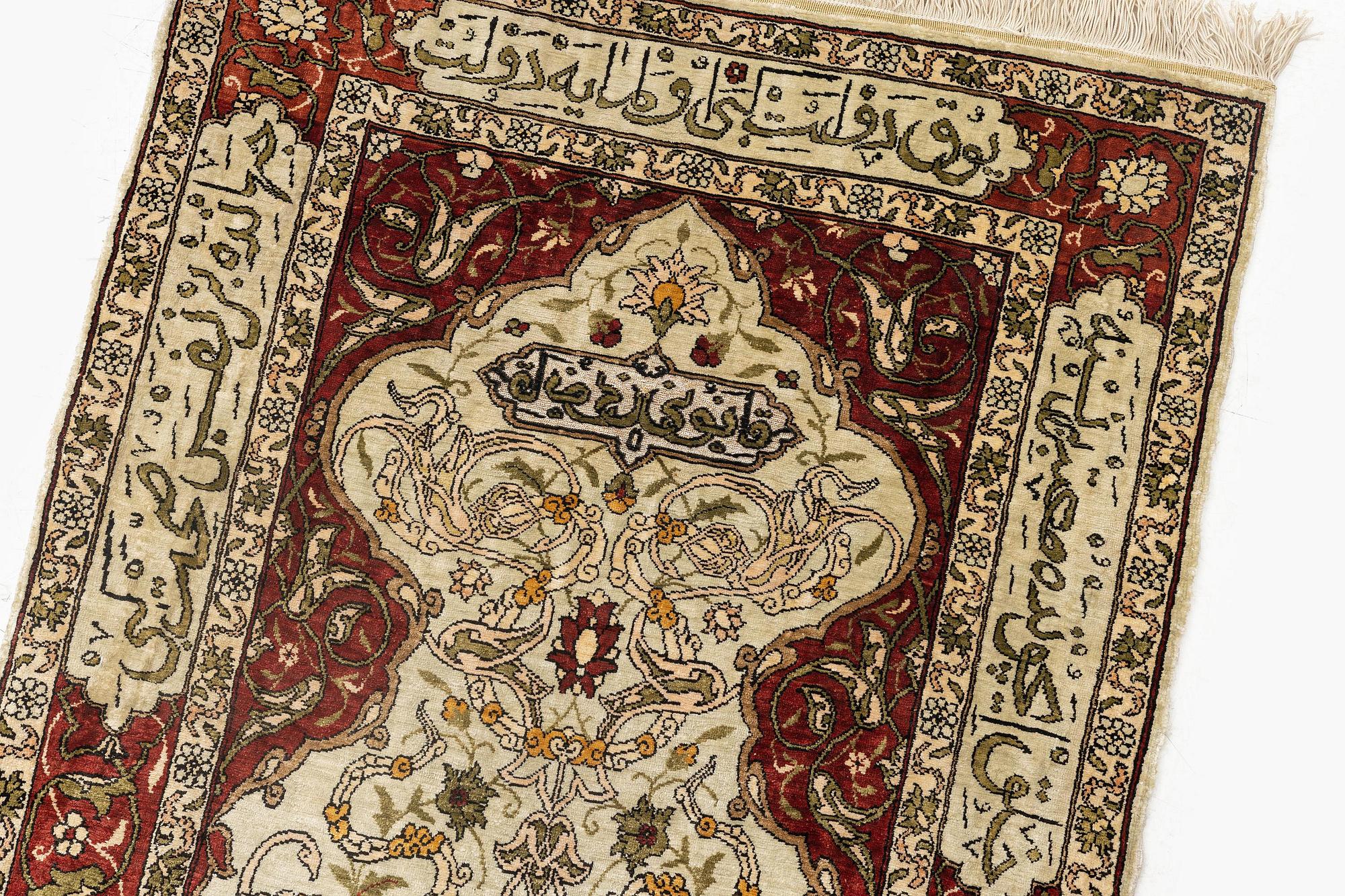 A silk and metal Hereke rug, c. 80 x 51 cm.