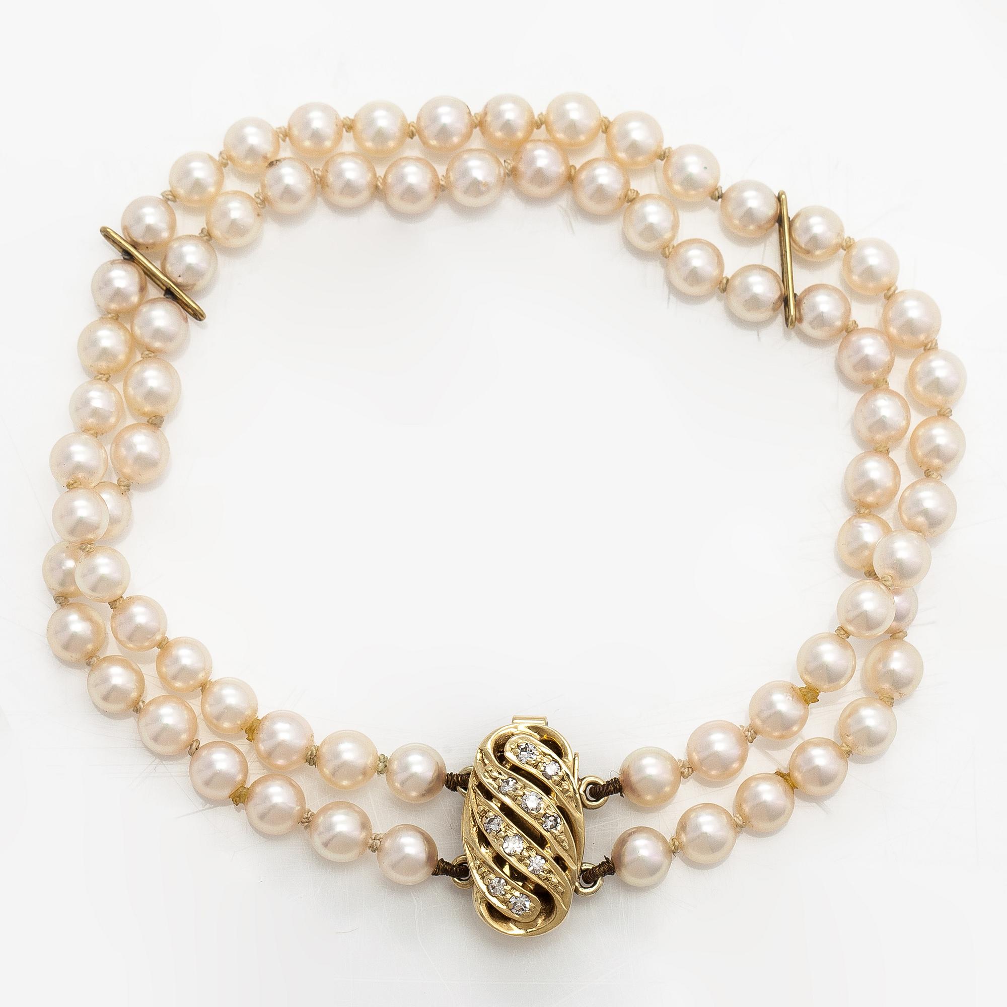 A 2-strand pearl bracelet with cultured pearls, lock 14K gold and diamonds, ca 0.13 ct in total.
