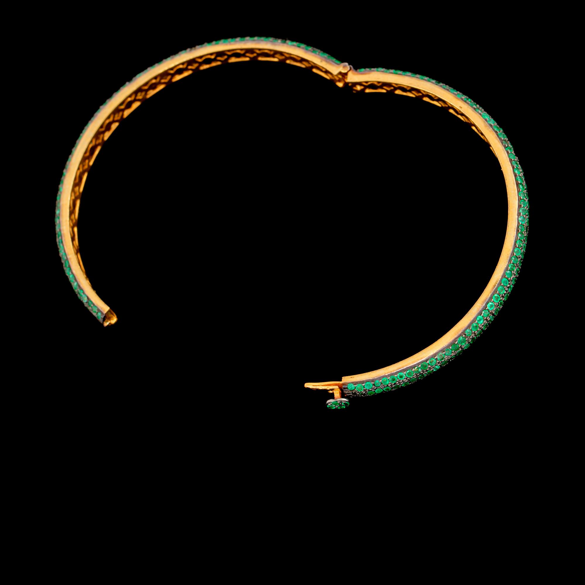 ARMRING, guld på silver samt fasettslipade smaragder. Vikt 16 g.
