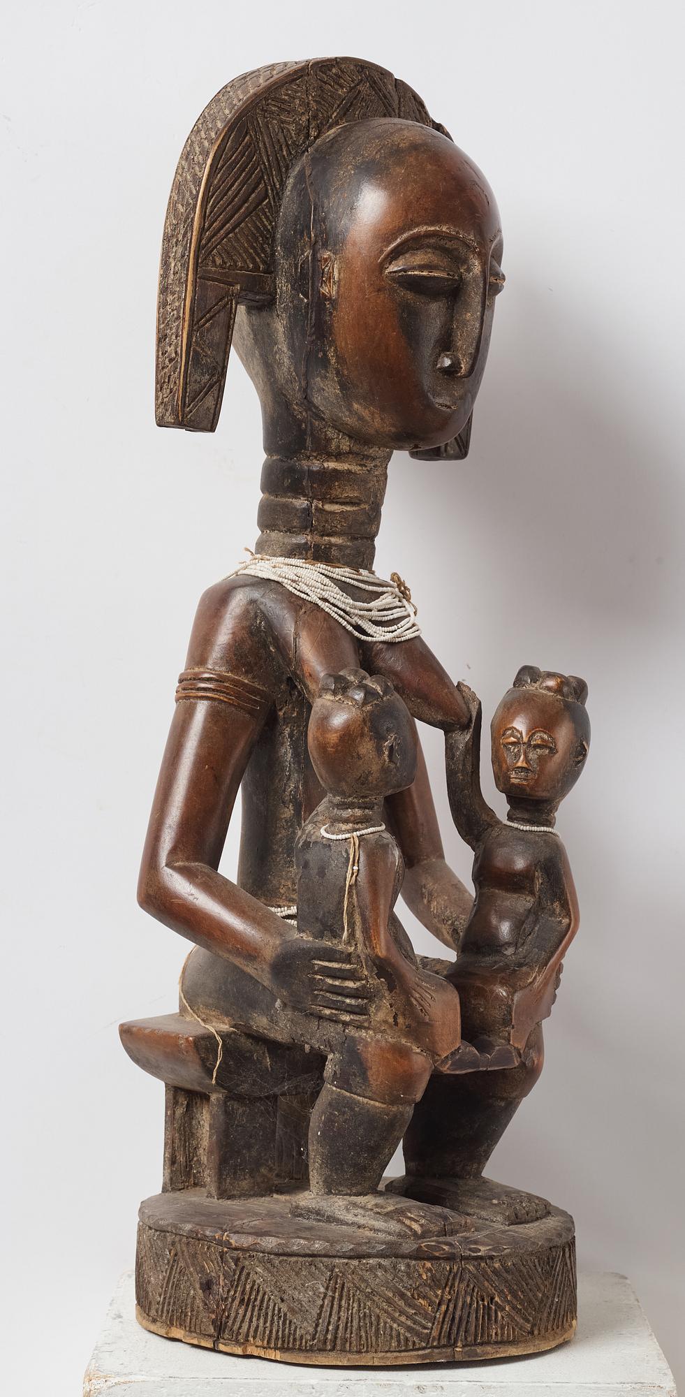 A sculptue and two masks reportedly from The Ivory coast, from the second half of the 20:th century.